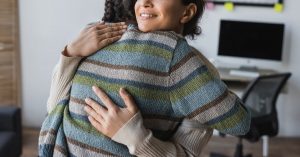 Image of a woman hugging another woman. Representing the benefits of meeting with an online couples therapist for marriage counseling whether you are in Raleigh, Chapel Hill, Durham, or anywhere in North Carolina.