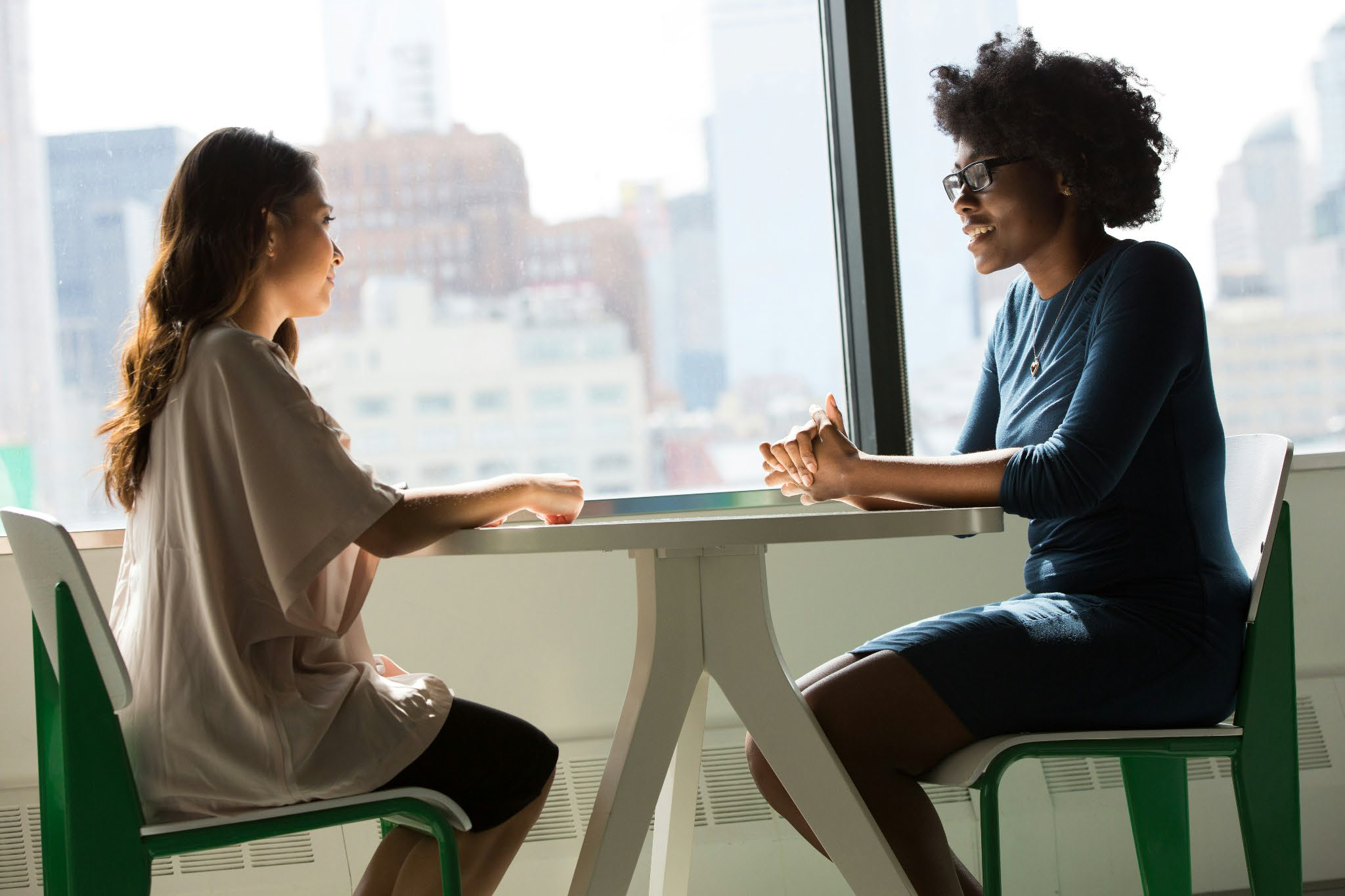 Therapist and client engaging in a supportive conversation in a light-filled office, representing compassionate EMDR trauma therapy in Durham NC and via telehealth across NC and SC