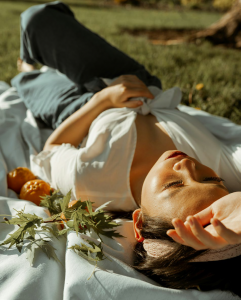 A woman resting peacefully on a blanket in the grass, symbolizing emotional relief and calm after EMDR therapy in North Carolina and South Carolina