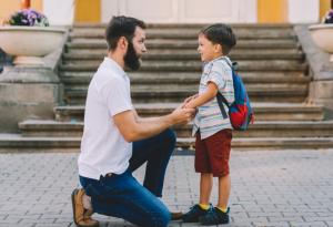 Father talking with young child outside school, symbolizing parental capacity evaluations and parenting assessments in North Carolina custody cases